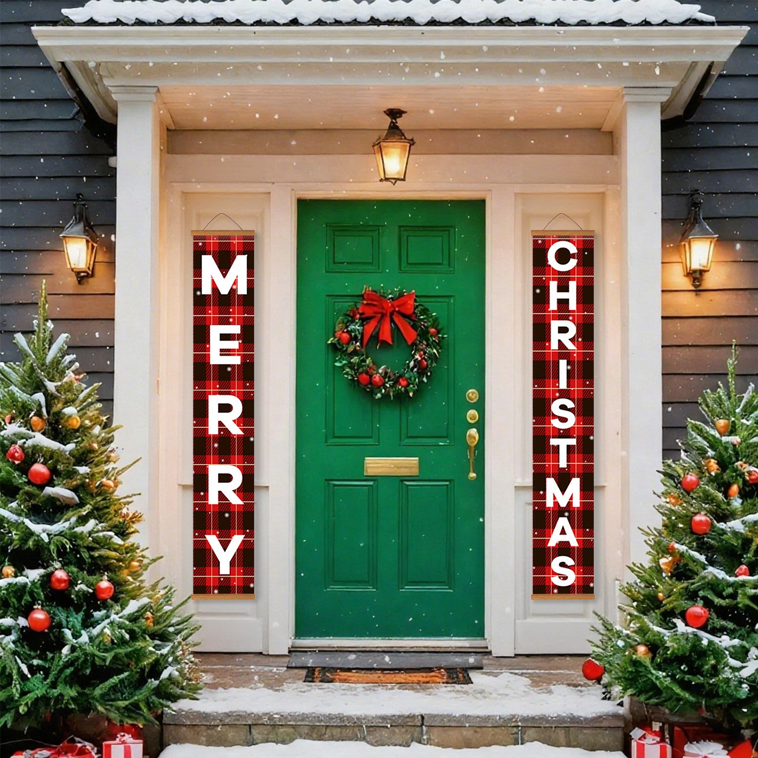 Puerta verde con corona flanqueada por carteles de "Feliz Navidad" en un porche nevado.