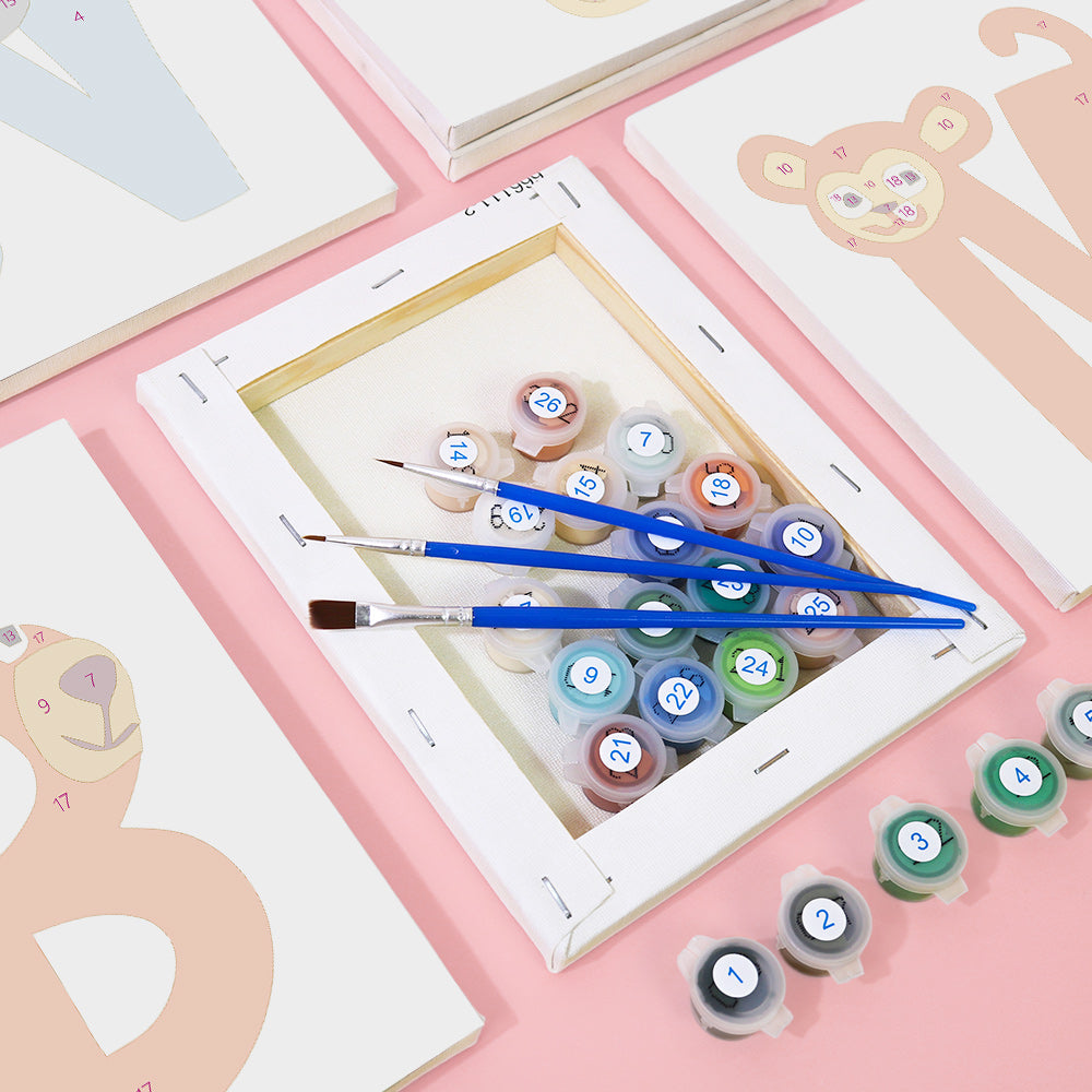 Artistic painting set with brushes and color swatches on a pink surface