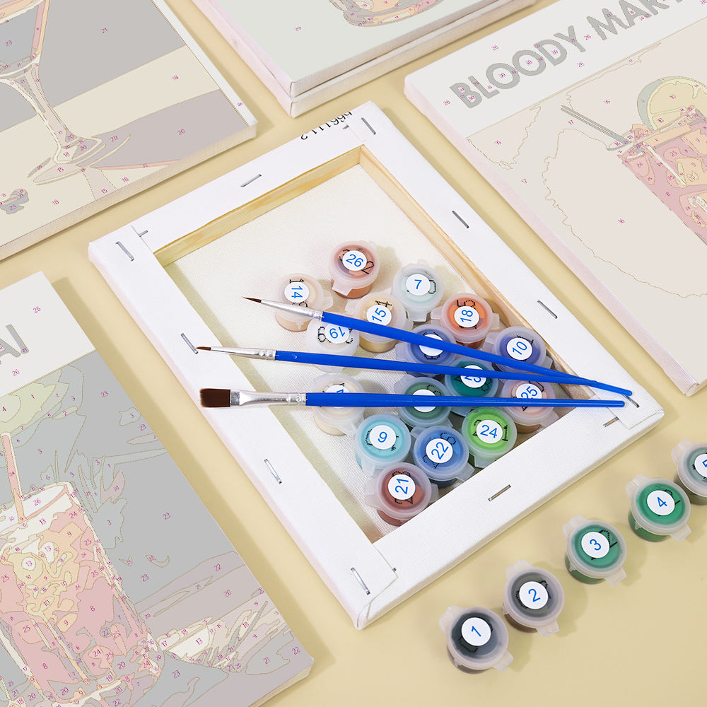 Person holding Sip Happens Mini Paint by Numbers Kit ready to paint