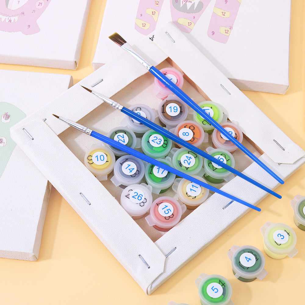 Set of paintbrushes and small bottles with numbers on a yellow surface