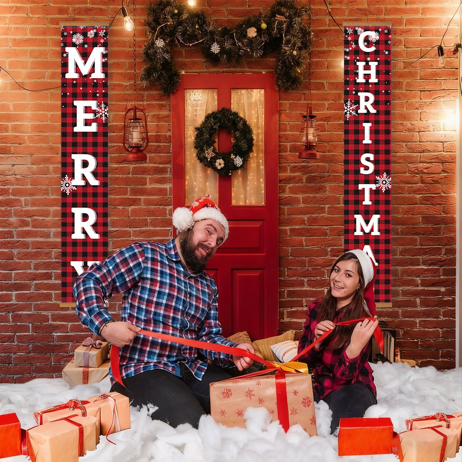 Two people in festive attire sitting on a snowy floor with Christmas decorations and presents.