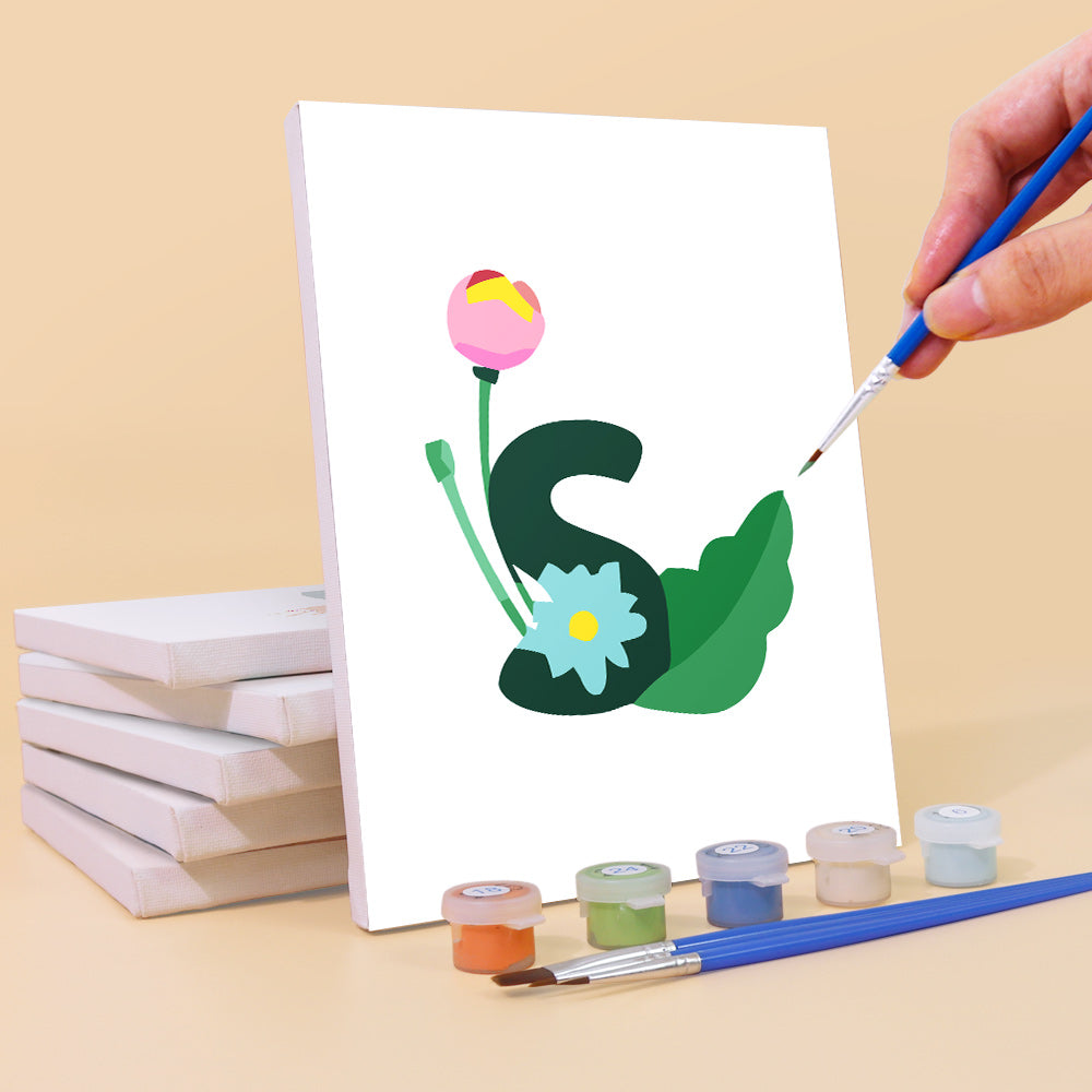 Handbemalung eines Buchstabens „S“ mit Blumen auf einer weißen Karte, umgeben von Farbbehältern und Pinseln.