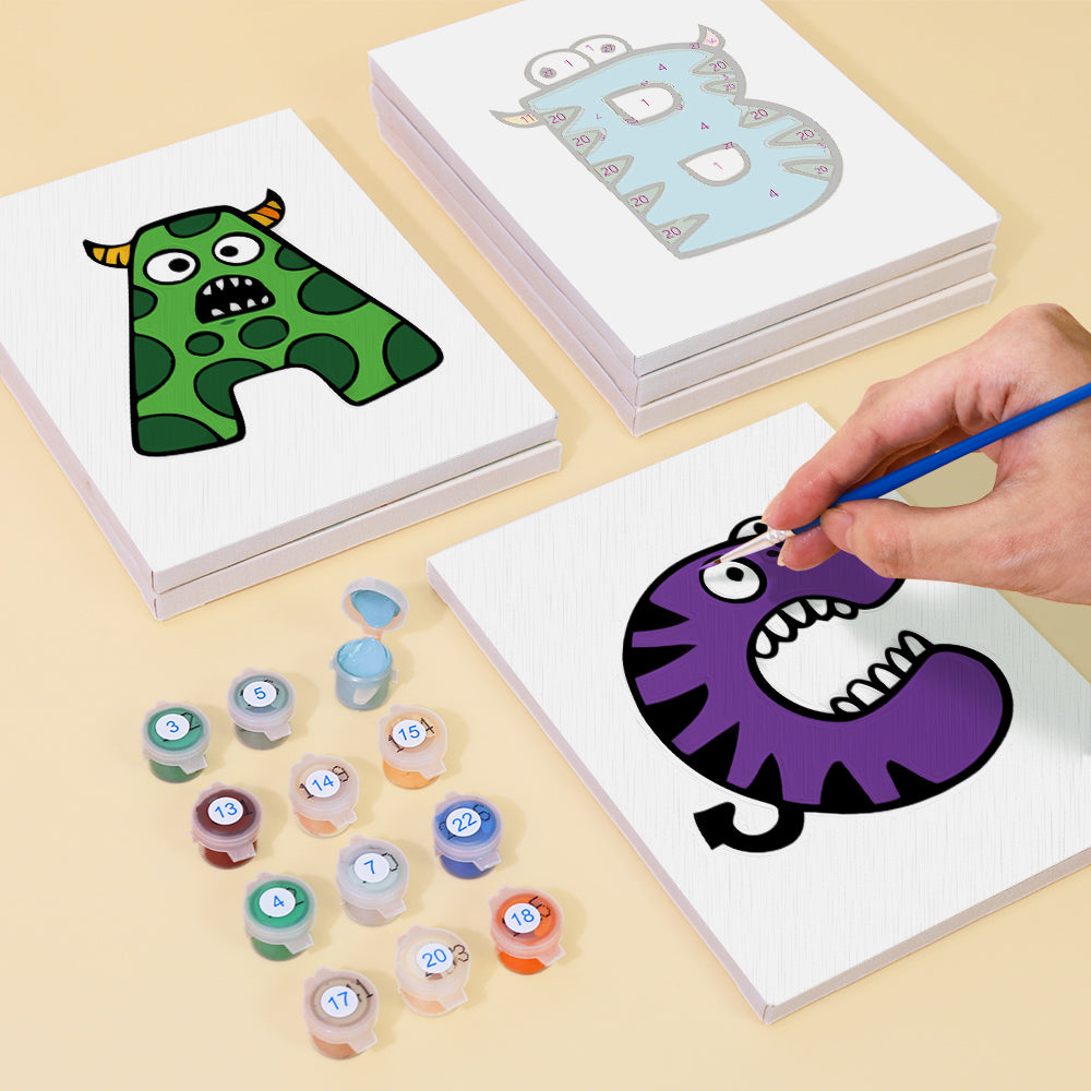 Coloring book with cartoon monsters and paint containers on a beige surface