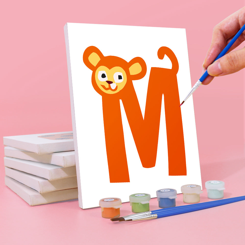 Hand painting a cartoon lion with an 'M' on a white canvas against a pink background.