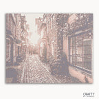 Paint by numbers kit of Old Town at sunset with warm glowing skies and rustic buildings