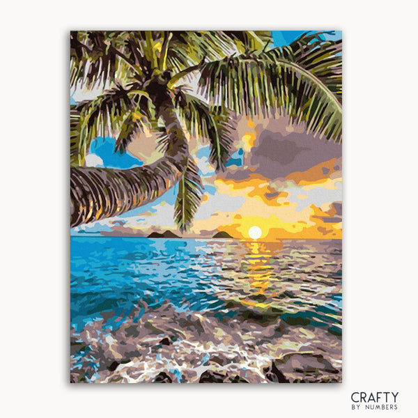 A painting kit representation of a Hawaiian scene with a palm tree, ocean waves, and a colorful sunset.