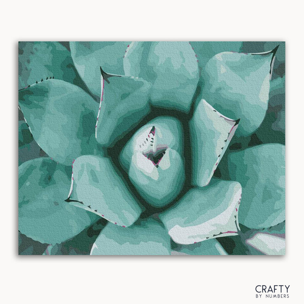 A framed painting of a succulent plant with a focus on its textured leaves in shades of green.