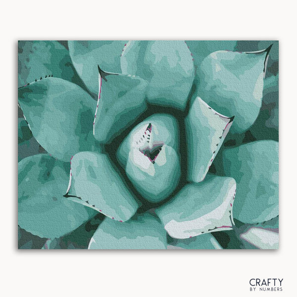 A framed painting of a succulent plant with a focus on its textured leaves in shades of green.