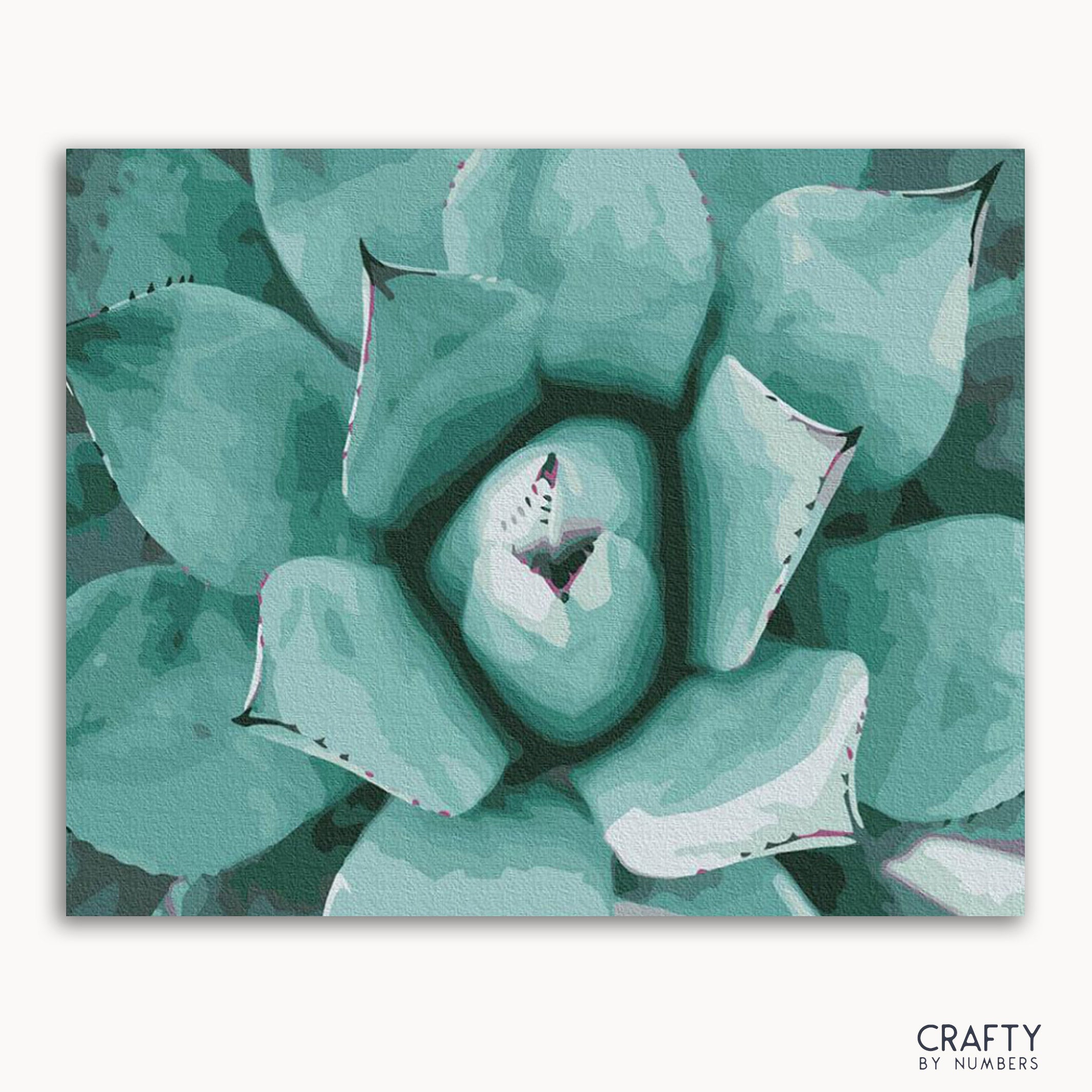 A framed painting of a succulent plant with a focus on its textured leaves in shades of green.