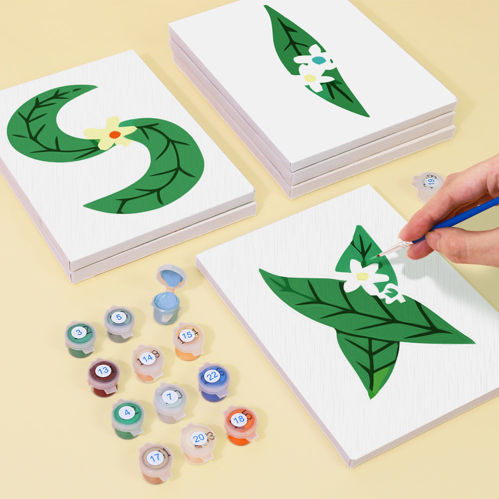 Children's craft activity with leaf and flower designs on cards and paint containers.
