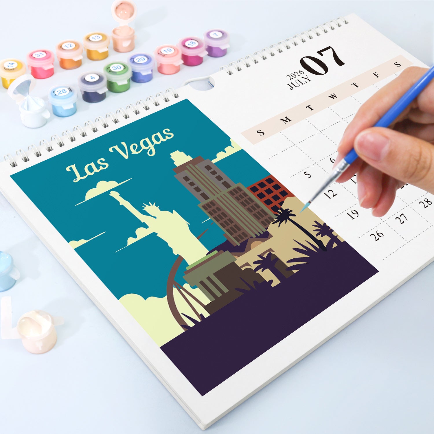 Calendar with Las Vegas illustration and hand holding a pen