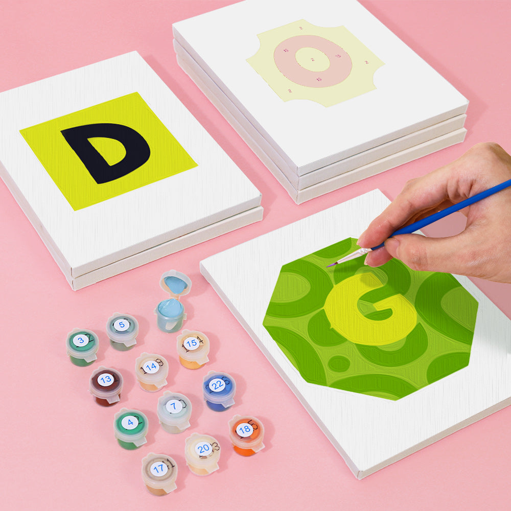 Children's art activity with letter 'G' painting and color swatches on a pink background