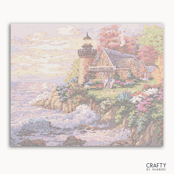 A paint by numbers kit depicting a small lighthouse scene with ocean and flowers.
