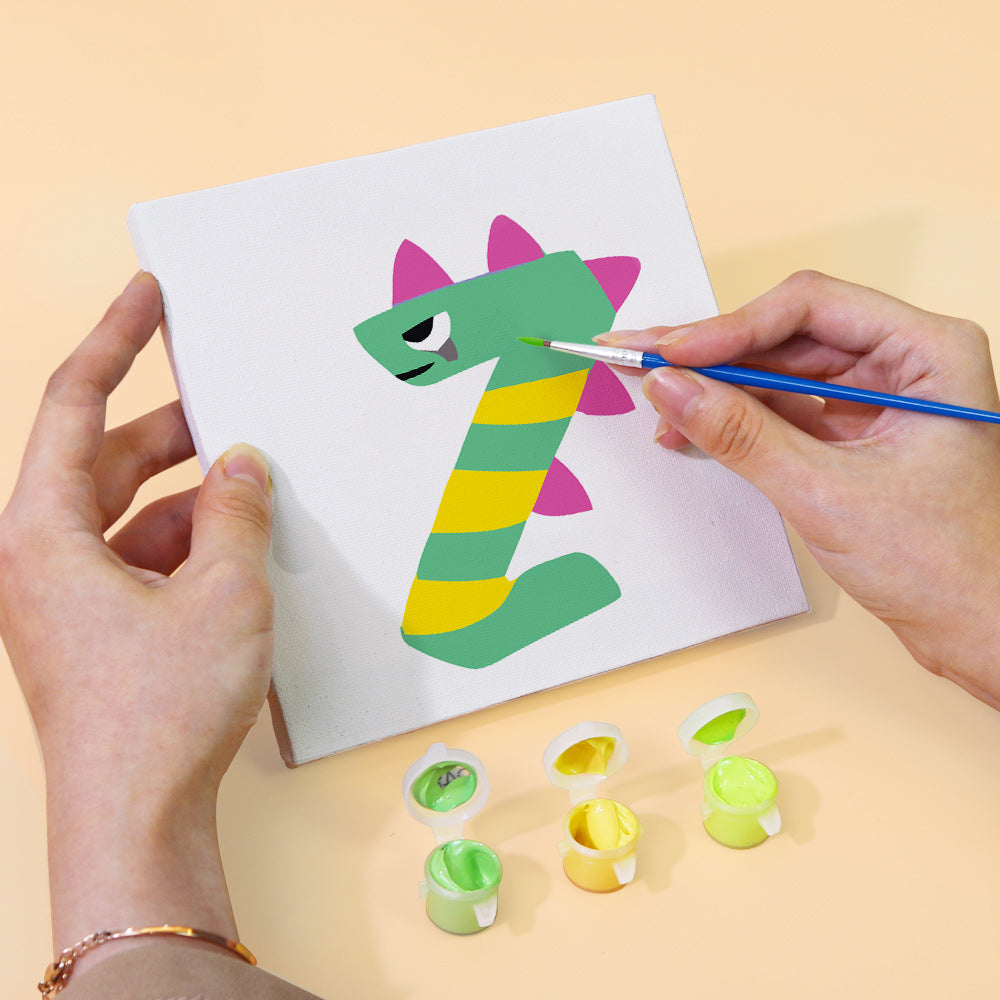 Person painting a number one with a dragon design on a white card, using small paint pots.