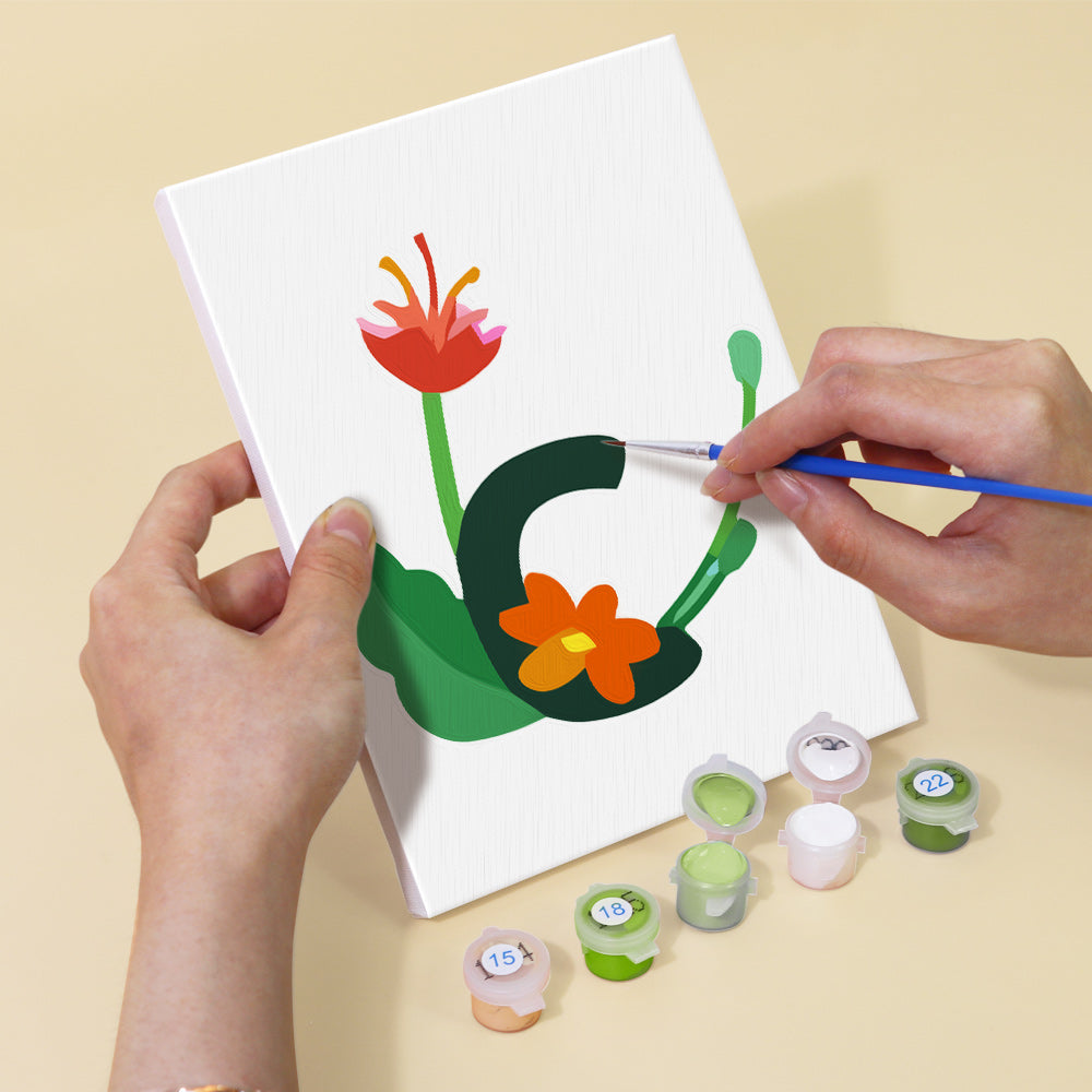 Person painting a floral design on a white canvas with paint supplies on a beige background