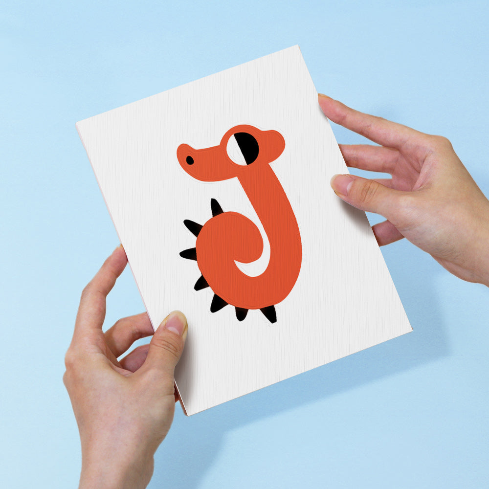 Card with a red dragon illustration held by two hands against a light blue background