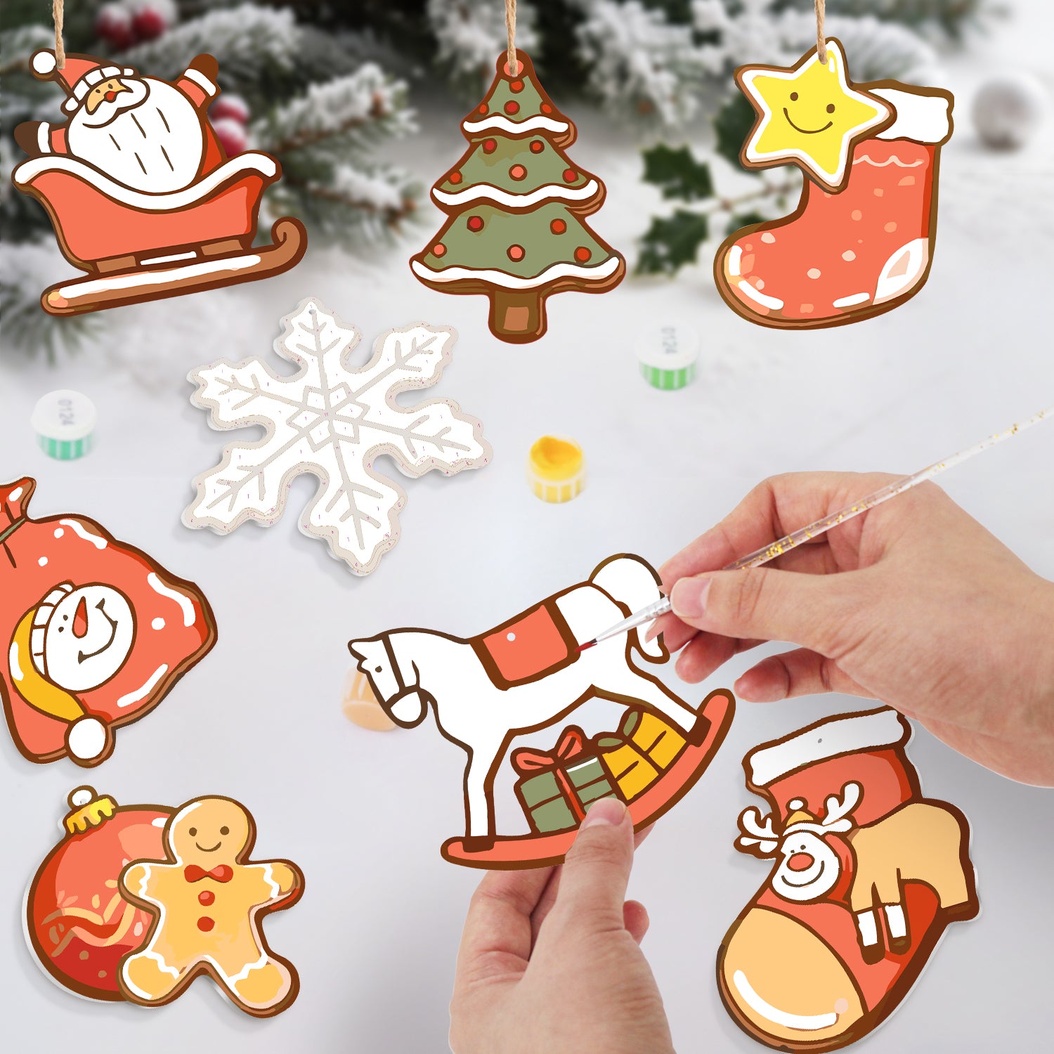Handmade Christmas ornaments with a person using a paintbrush on a snowy background