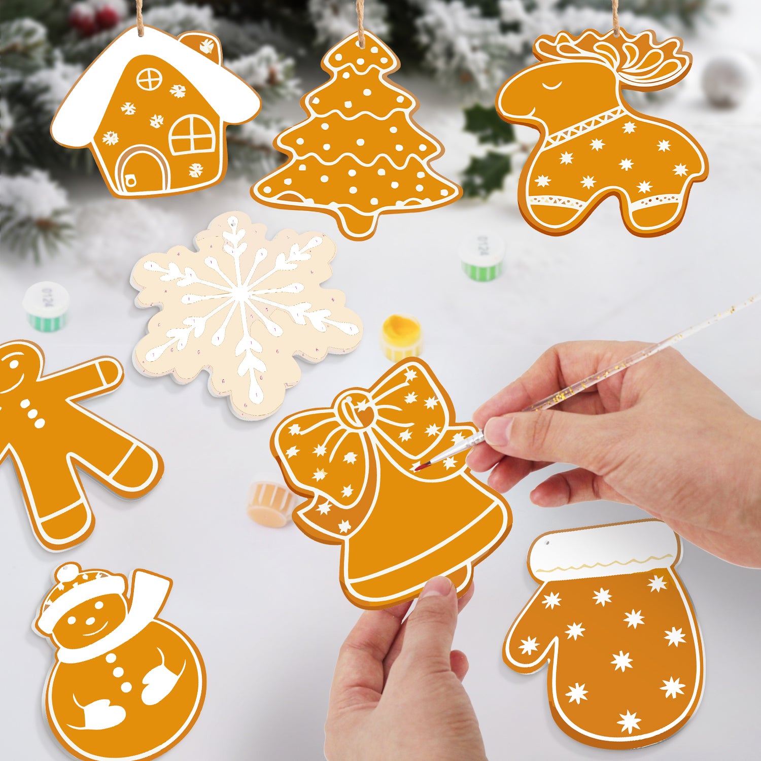 Décorations de Noël faites à la main sur le thème du pain d'épices sur une surface blanche avec un fond enneigé.