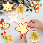 Decorative Christmas cookies being painted with a hand against a snowy background