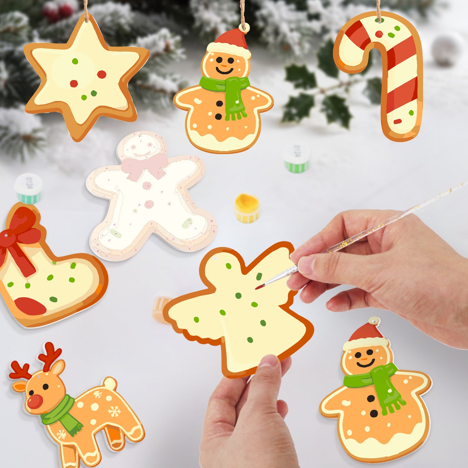 Decorative Christmas cookies being painted with a hand against a snowy background