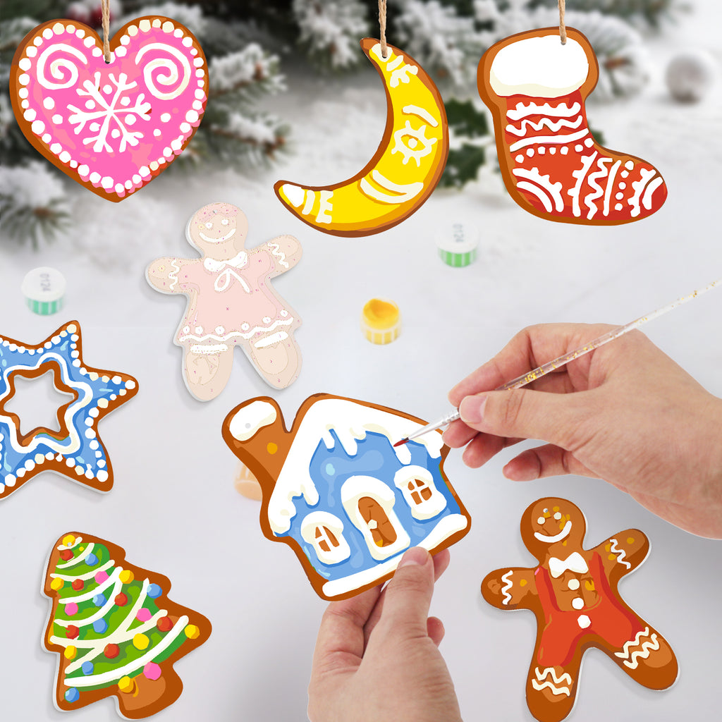 Decorative gingerbread cookies shaped like a heart, moon, stocking, star, tree, and gingerbread man on a snowy background.