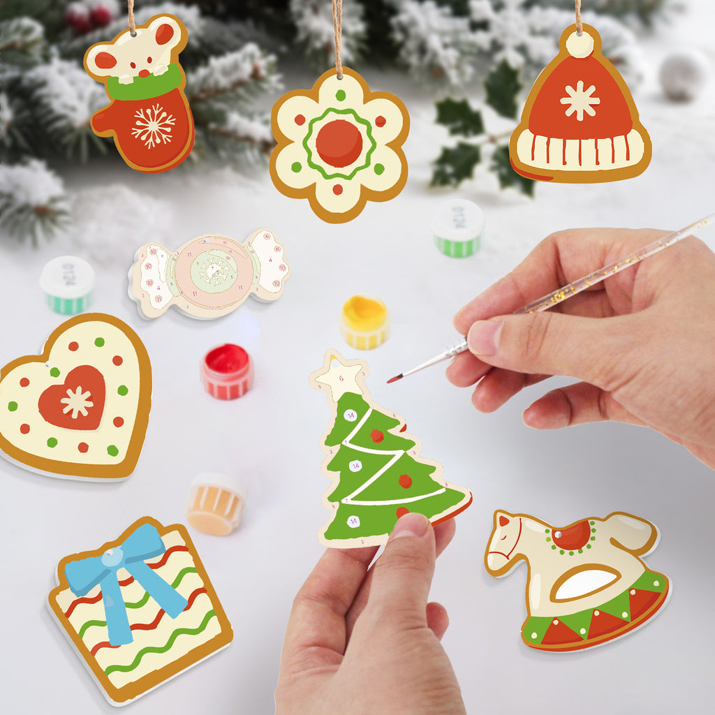 Colorful Christmas-themed cookie cutout decorations with a hand painting one of them.