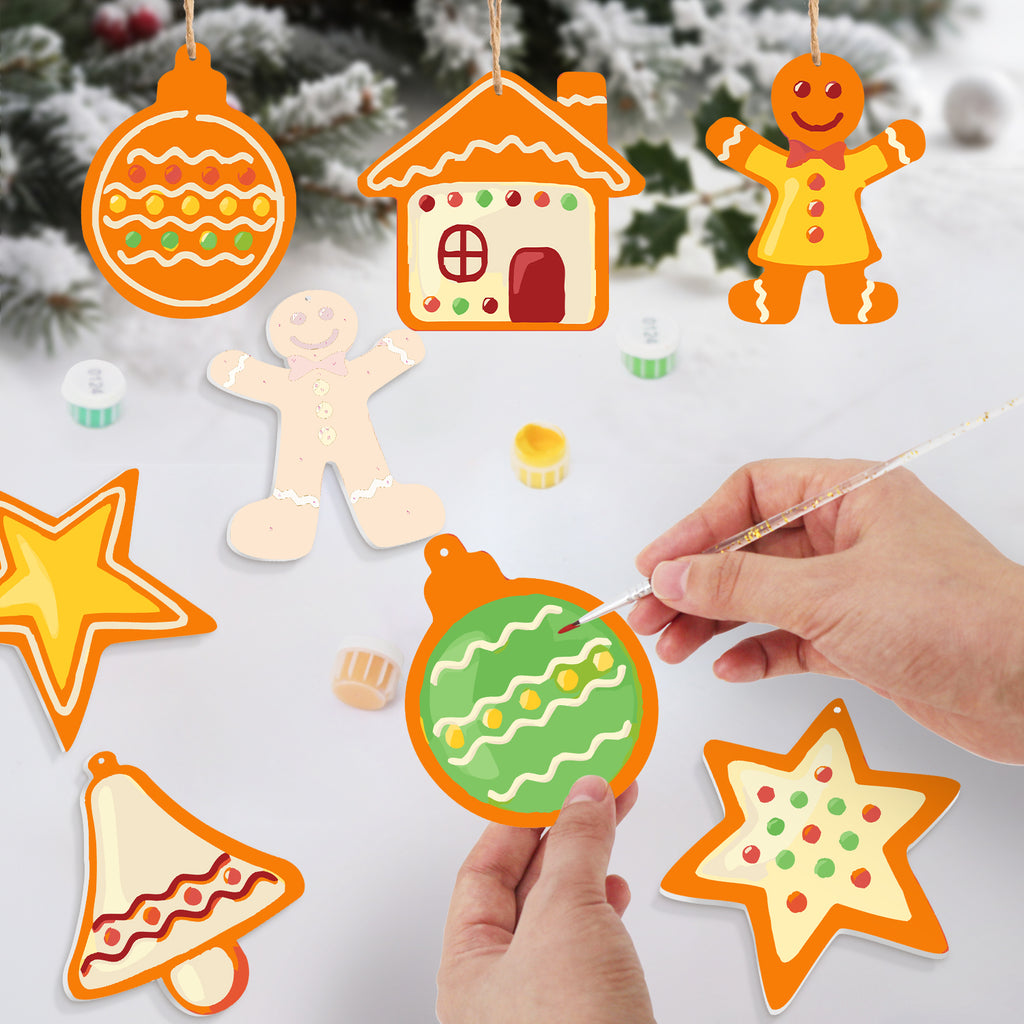 Decorative Christmas ornaments being painted with a hand holding a paintbrush.