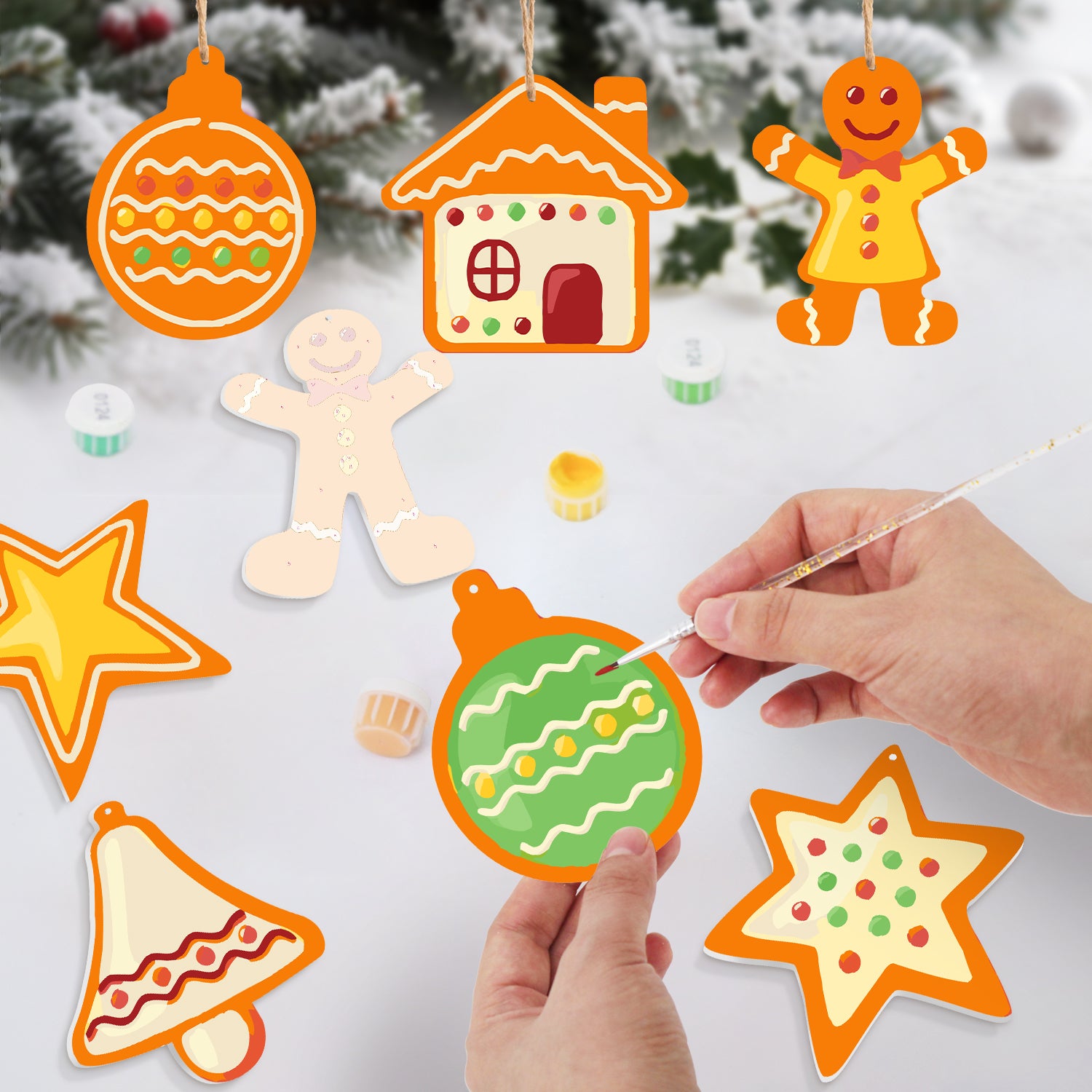 Decorative Christmas ornaments being painted with a hand holding a paintbrush.