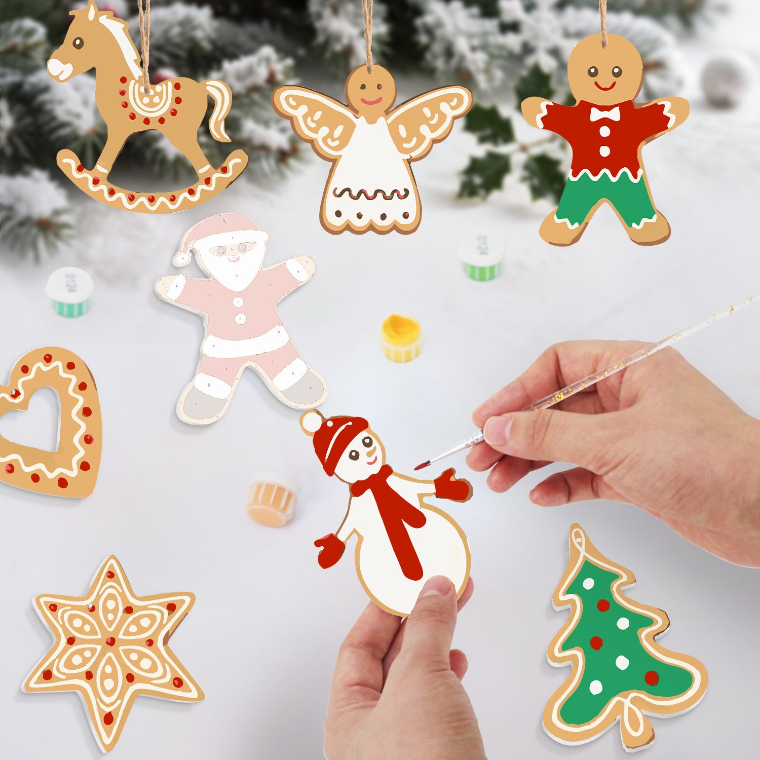 Ornements de Noël décoratifs en forme de biscuits en pain d'épice sur une surface blanche avec un fond enneigé.