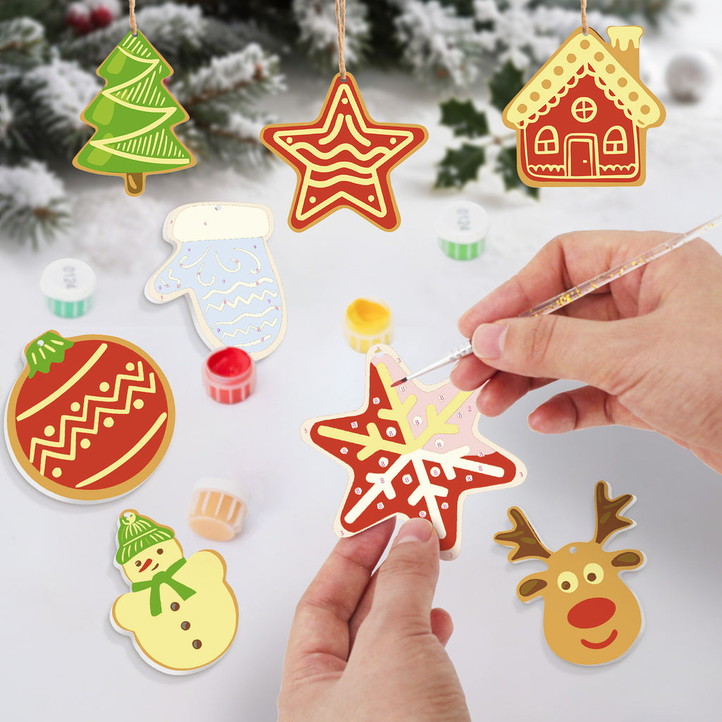 Colorful Christmas-themed paper cutouts with a hand using a paintbrush.