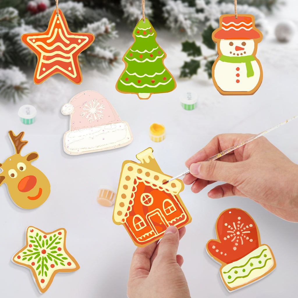 Colorful Christmas-themed cookie cutters being held by hands with a snowy background.