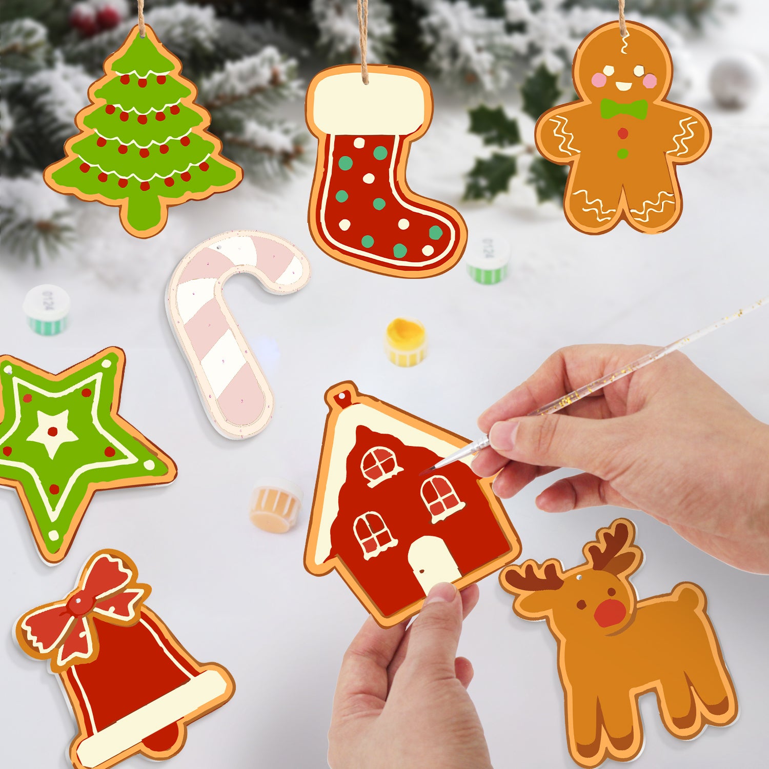 Decorative Christmas ornaments including a house, tree, stocking, and reindeer on a snowy background.