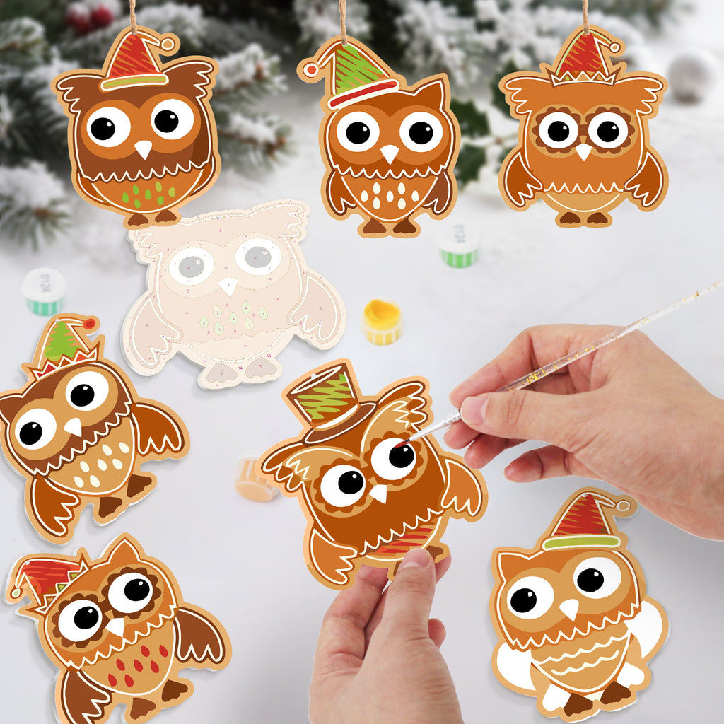 Decorative owl ornaments with festive hats on a snowy background