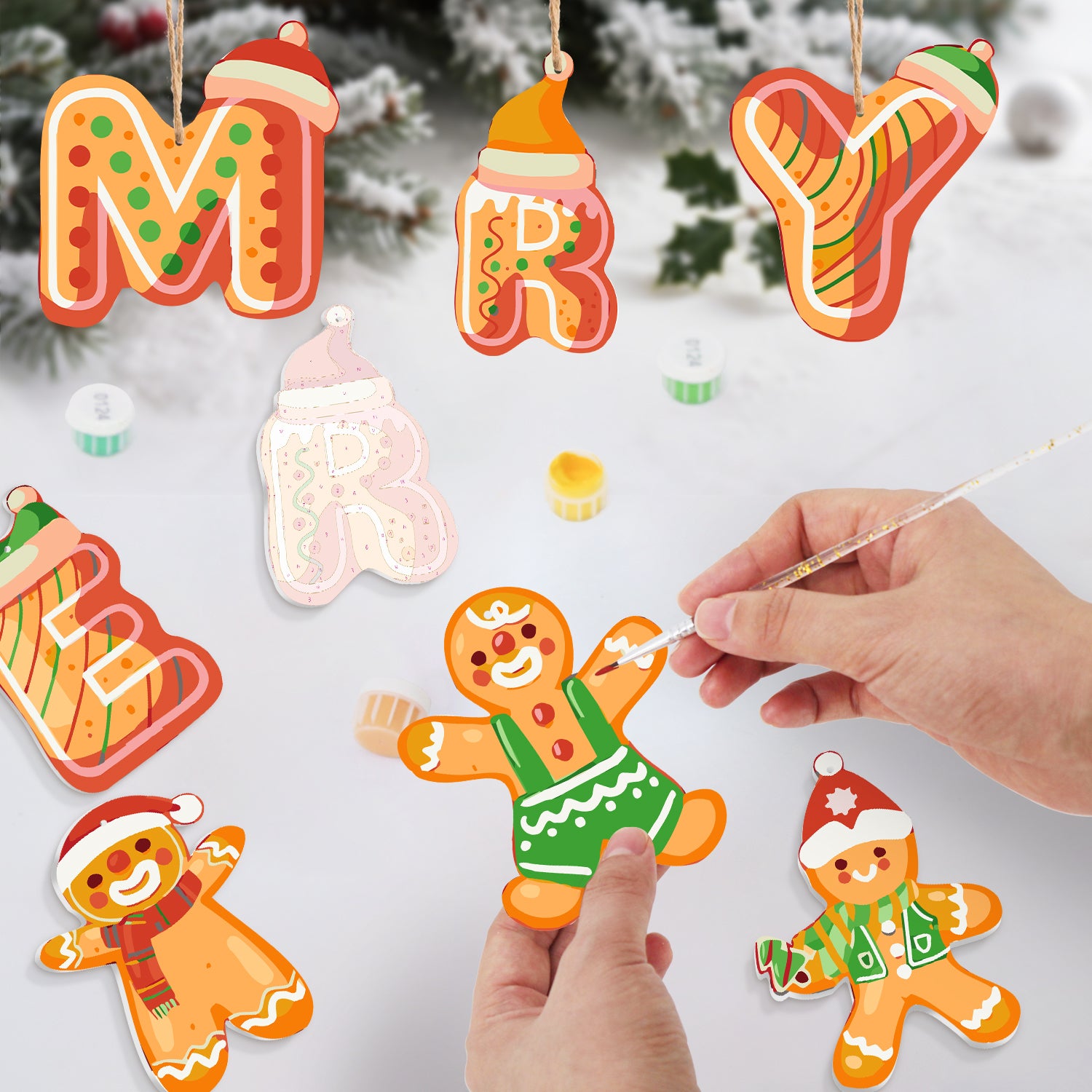 Decorative Christmas ornaments shaped like letters and gingerbread men on a snowy background.