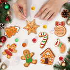 Decorative Christmas cookies being crafted with icing on a white surface.