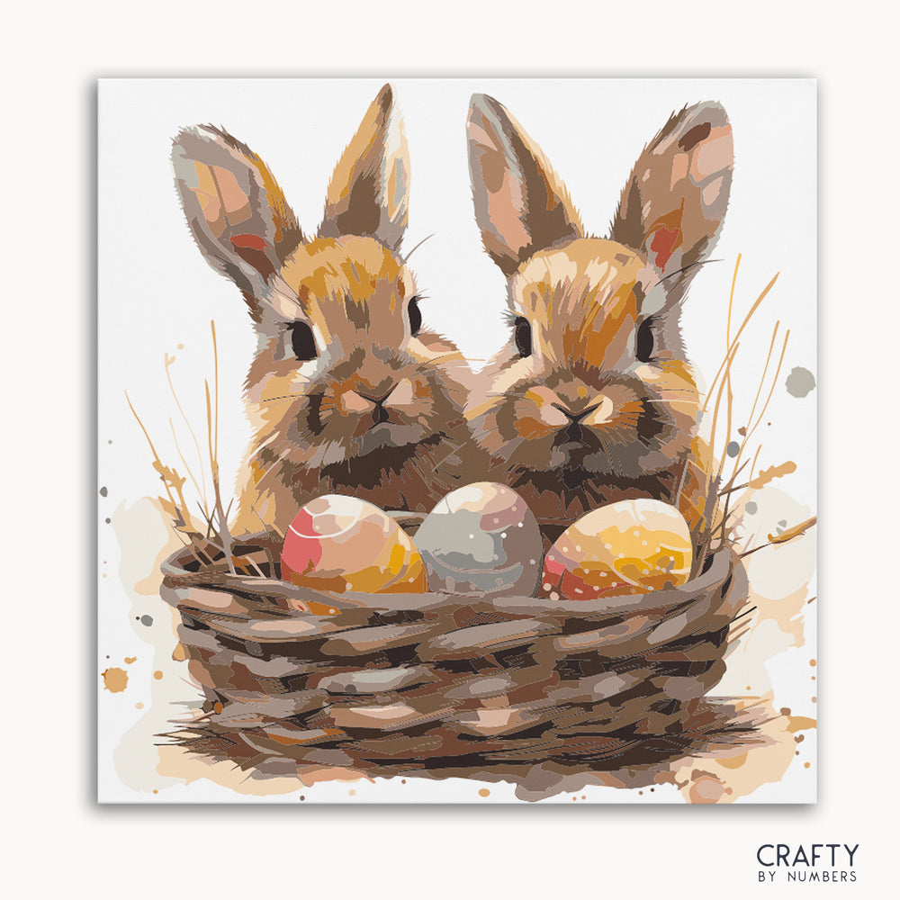 A painting kit depicting two stylized bunnies with Easter eggs in a basket, with the brand 'Crafty by Numbers' visible.