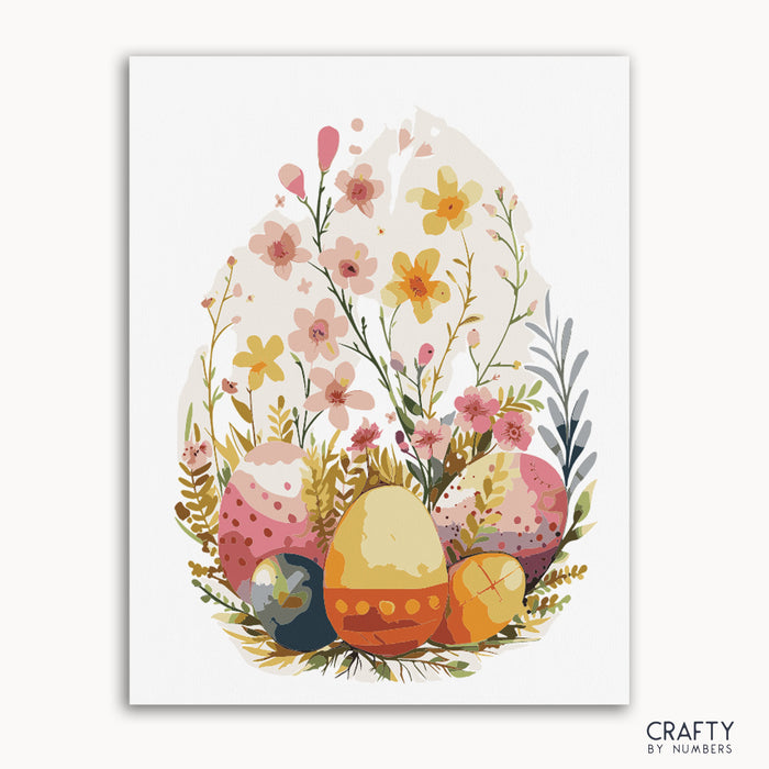 A paint by numbers kit with a floral design featuring eggs and spring flowers, presented on a white background with 'Crafty by Numbers' branding.