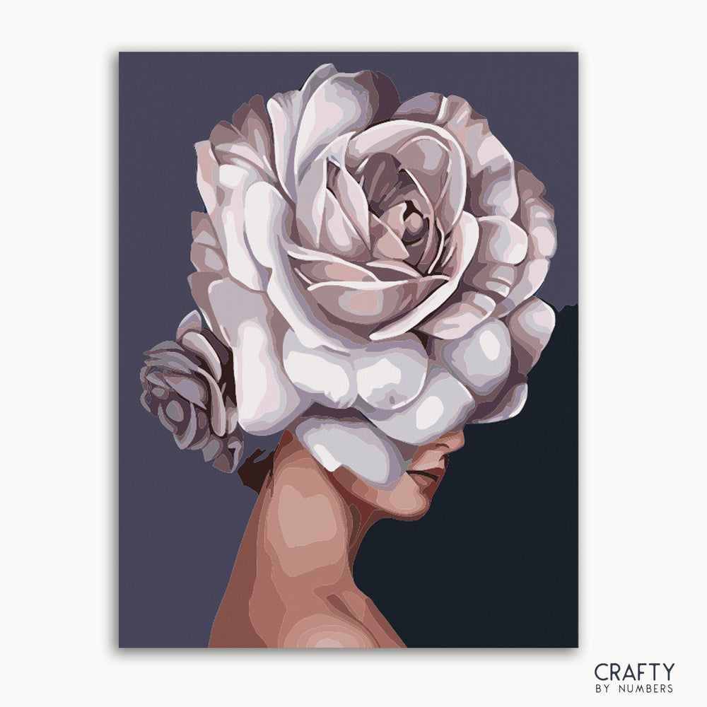 A paint-by-numbers kit depicting a woman's profile with a floral design in shades of white and gray.