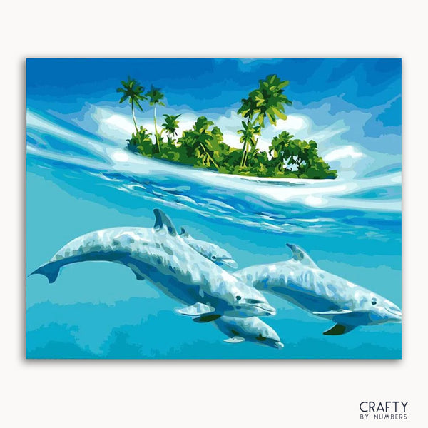 A framed canvas painting depicting dolphins in blue water with a tropical island in the background, including palm trees and clear sky.