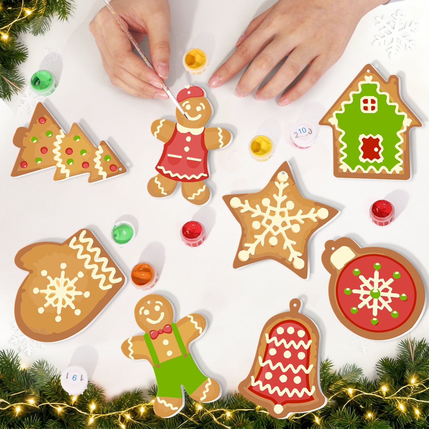 Biscuits décoratifs en pain d'épice en forme de maison, d'étoile, de cloche et d'autres motifs festifs sur une surface blanche avec des décorations de Noël.