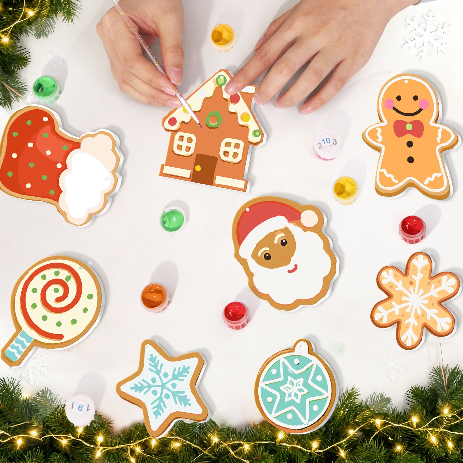 Galletas de jengibre decorativas con forma de Papá Noel, una casa y otras figuras navideñas sobre una superficie blanca con adornos festivos.