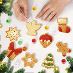 Decorative Christmas cookies being painted on a white surface with festive decorations around.