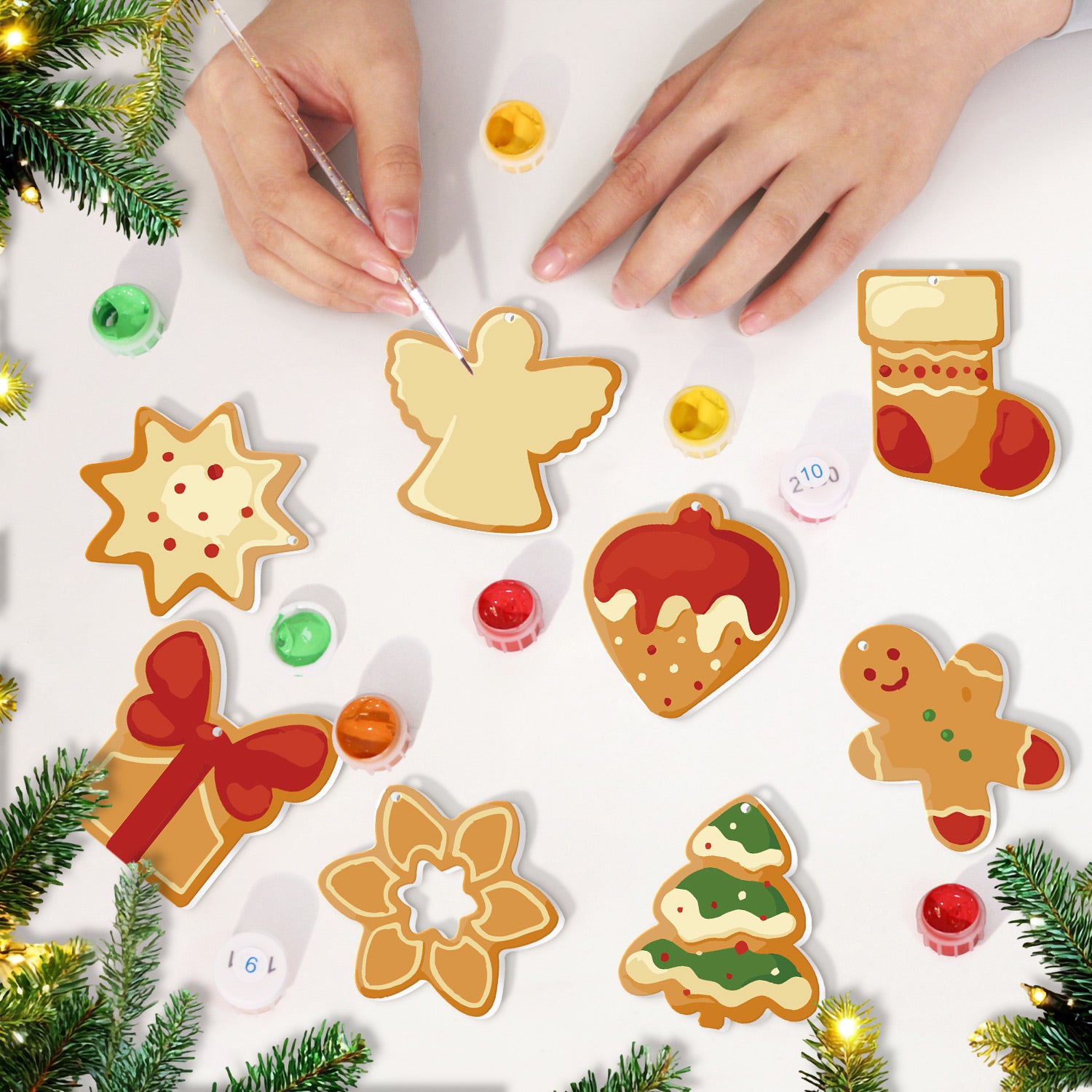 Biscuits de Noël décoratifs peints sur une surface blanche avec des décorations festives autour.