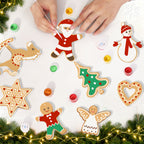 Christmas-themed cookie cutters on a white surface with decorative lights and greenery.