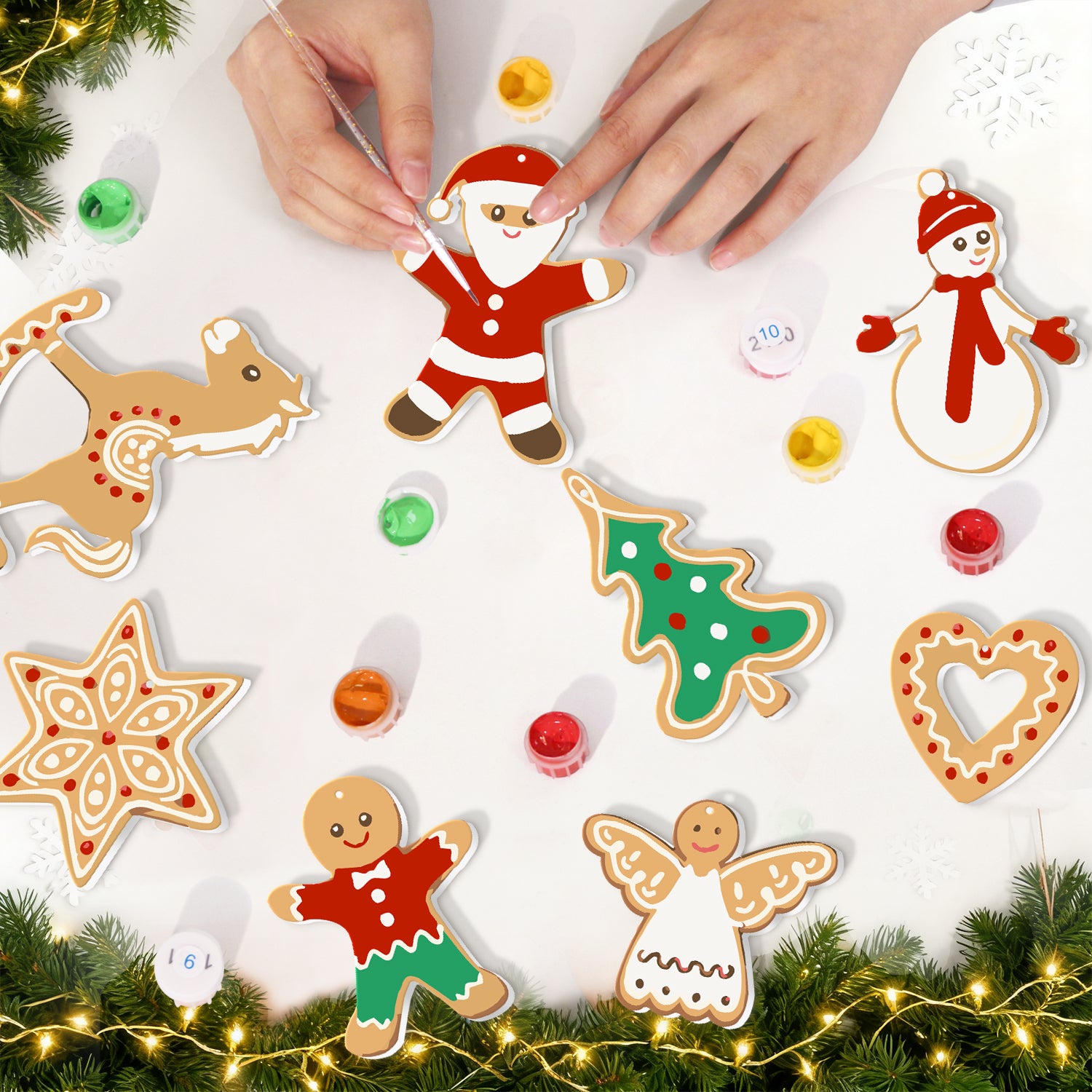 Emporte-pièces sur le thème de Noël sur une surface blanche avec lumières décoratives et verdure.