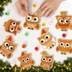 Decorative owl ornaments with festive hats on a white surface with Christmas decorations.