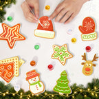 Decorative Christmas cookies shaped like a star, hat, mitten, gingerbread house, snowman, tree, and reindeer on a white surface with festive lights and decorations.