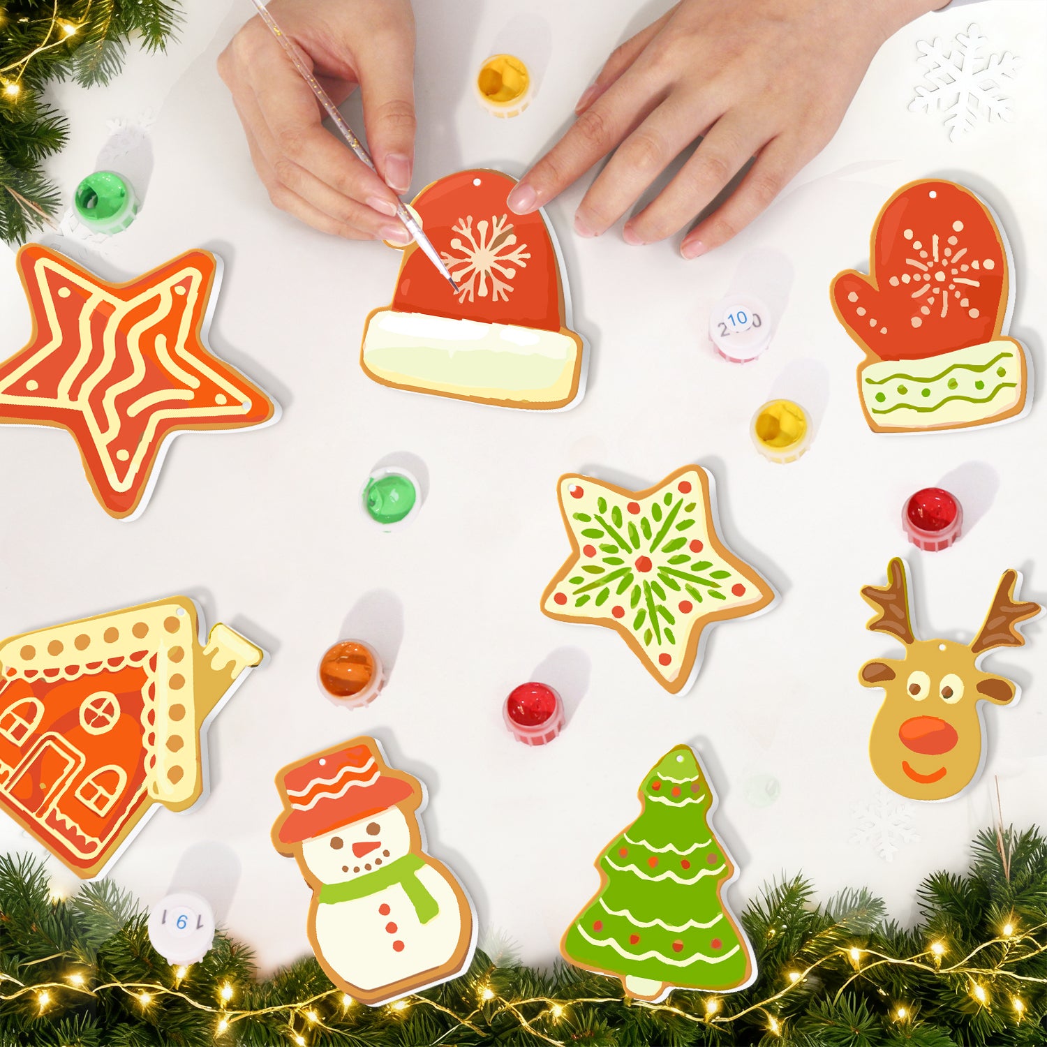 Decorative Christmas cookies shaped like a star, hat, mitten, gingerbread house, snowman, tree, and reindeer on a white surface with festive lights and decorations.