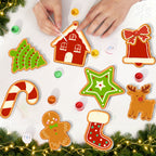 Decorative Christmas cookies shaped like a house, star, candy cane, gingerbread man, and bell on a white surface with festive decorations.