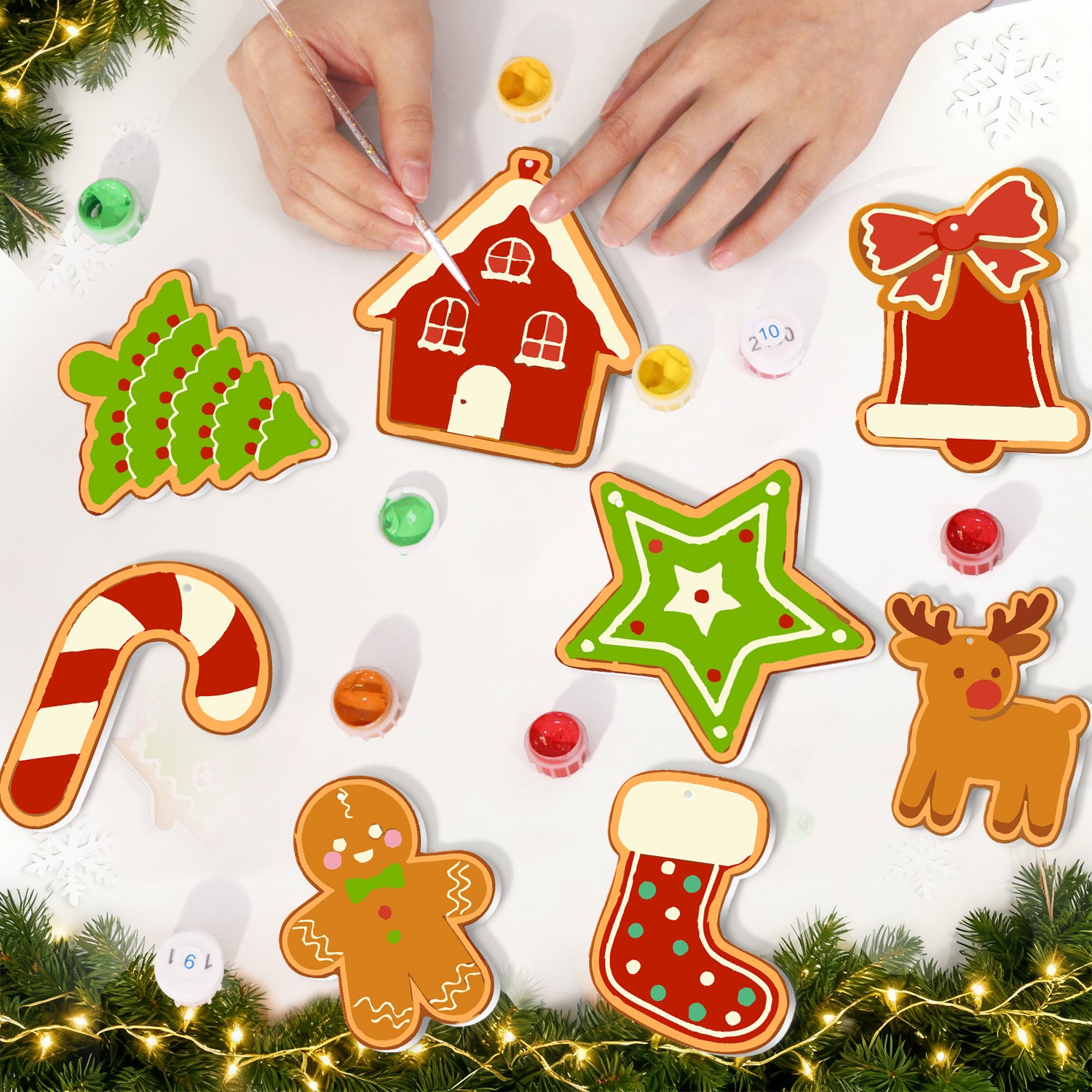 Decorative Christmas cookies shaped like a house, star, candy cane, gingerbread man, and bell on a white surface with festive decorations.